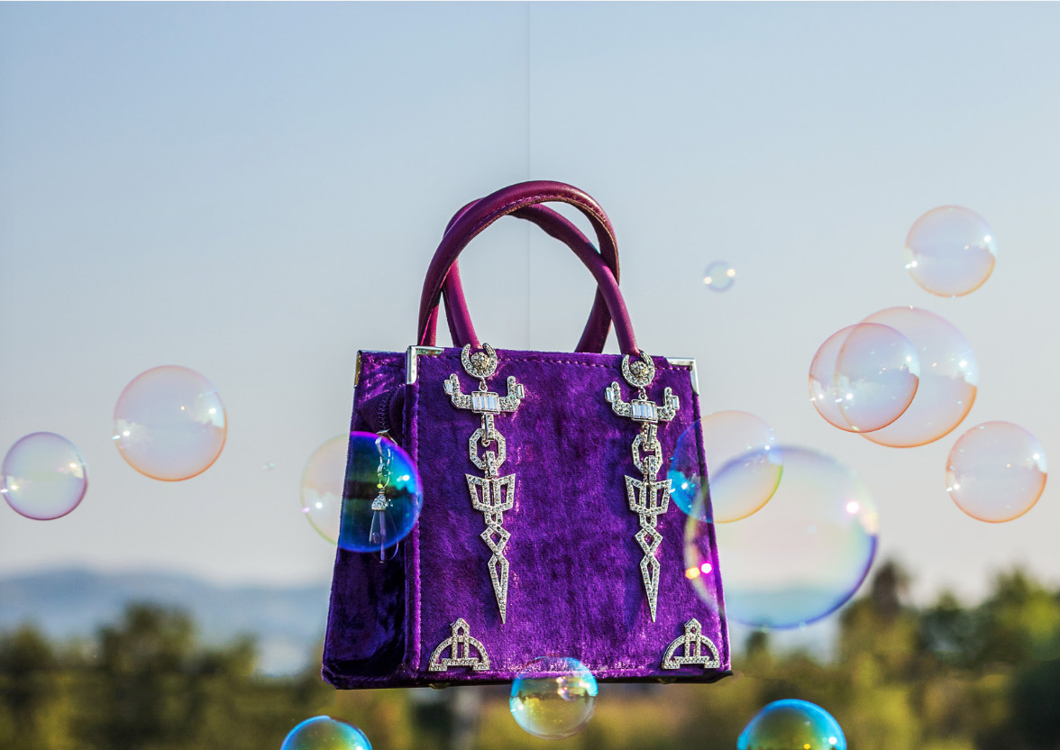Purple velvet Carlo Zini handbag with crystal appliqué photographed outdoors among soap bubbles, editorial photography by Sogand Nobahar