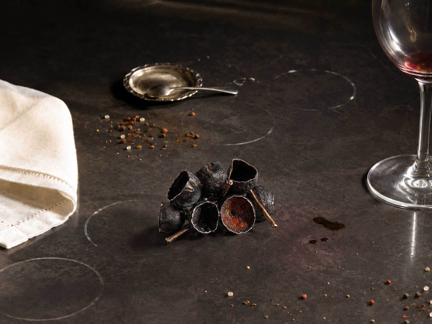ClaraDelPapa rings on a dark table beside a wine glass, generated environment by Sogand Nobahar