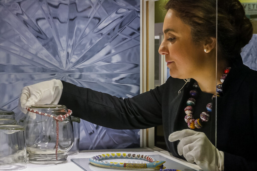 Bianca Cappello handling a cut glass support while installing the Vetro exhibition at Museo del Bijou di Casalmaggiore