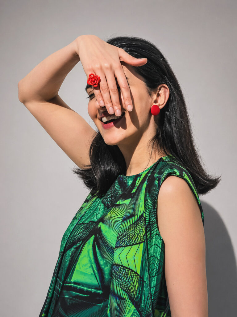 Red flower ring worn with a green printed dress, hand-pigmented sintered nylon jewelry by Nobahar Design