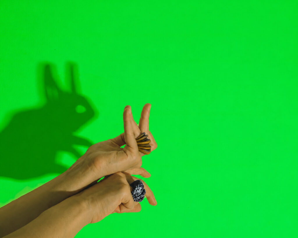 The ring worn on a finger against a green screen, a hand giving an immediate and exact sense of the piece's real size