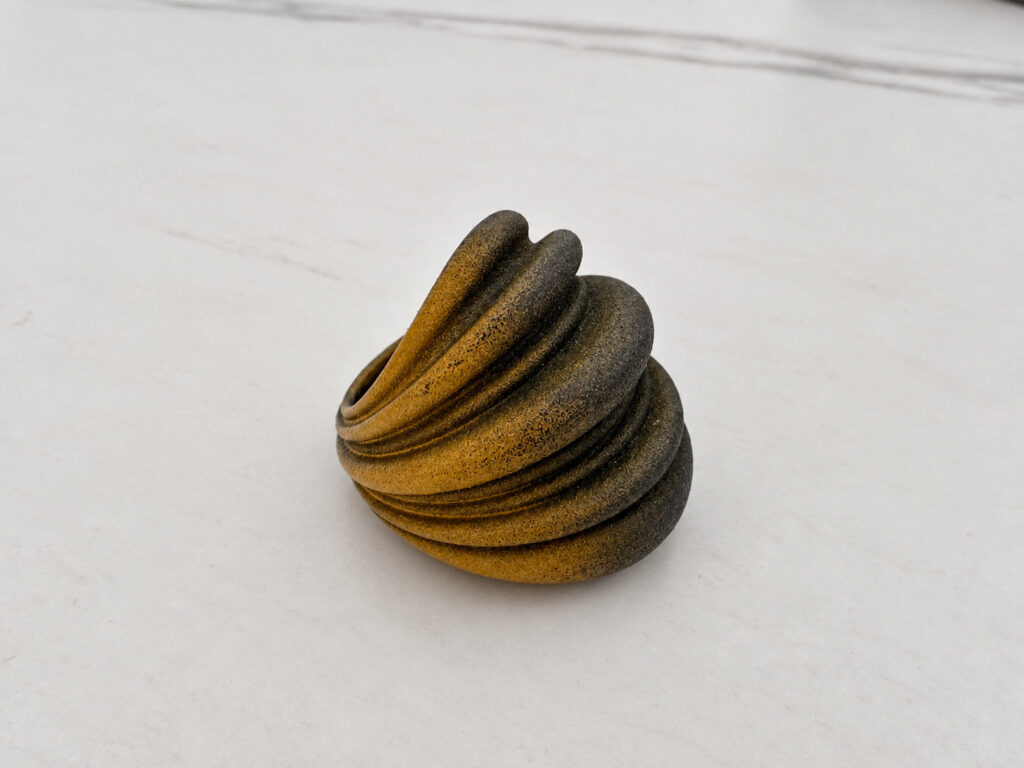The ring on a blank pale surface at three quarter view, competently lit but with nothing in the frame to judge its size against