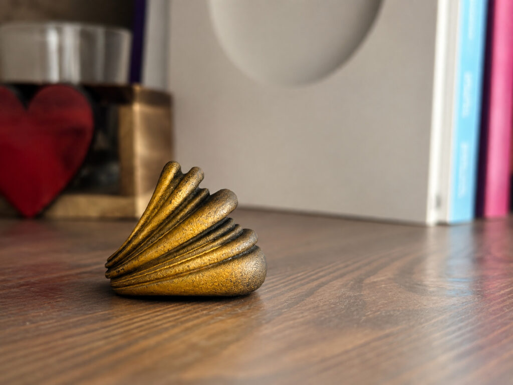 The same ring on a wooden desk beside books and a glass, the room and the wood grain making its real size immediately obvious